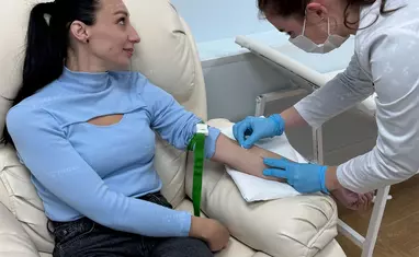 Медсестра клиники Мед Юг берет у пациентки в кресле кровь на анализы